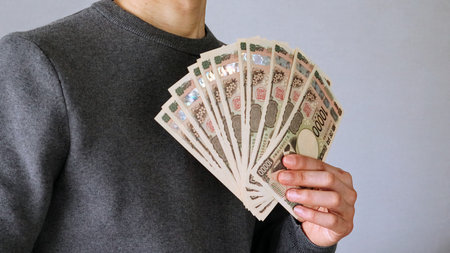 A person holding a large amount of 10,000 yen bills