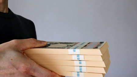 Close-up of a person holding a stack of bills
