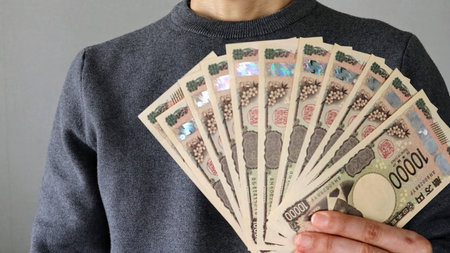 A person holding a large amount of 10,000 yen bills