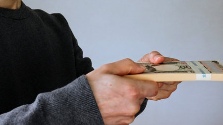 Close-up of a person holding a stack of bills