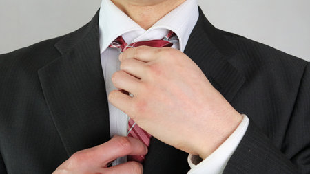 Close-up of a businessman tightening his tie