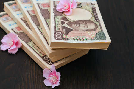 Cherry blossoms and a stack of banknotesの写真素材