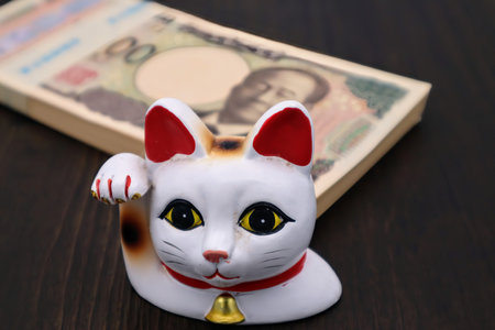 Maneki-neko and a stack of banknotesの写真素材