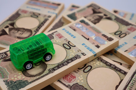 A stack of bills and a carの写真素材