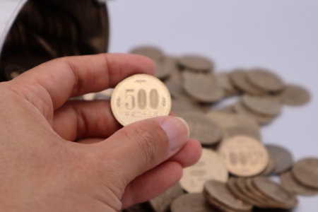 Person holding a 500 yen coin