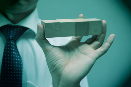A person holding a building block. Please write your favorite letters on the building blocks.