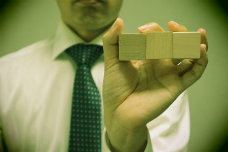 A person holding a building block. Please write your favorite letters on the building blocks.