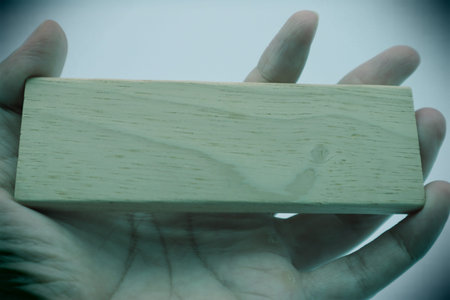 A person holding a building block. Please write your favorite letters on the building blocks.