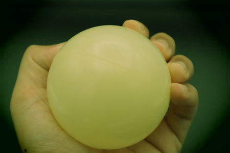 Close-up of a person holding a ball. Please write text on the ball.の写真素材