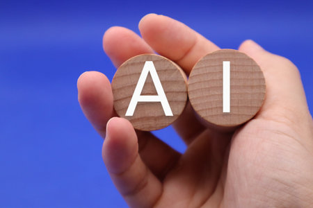 A person holding a building block with the word AI written on itの写真素材