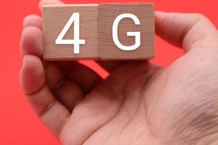 A person holding a building block with 4G written on itの写真素材