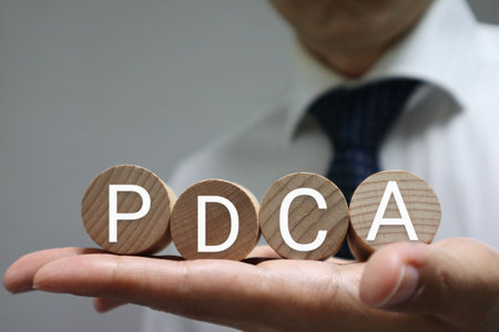 A person holding a building block with PDCA written on itの写真素材