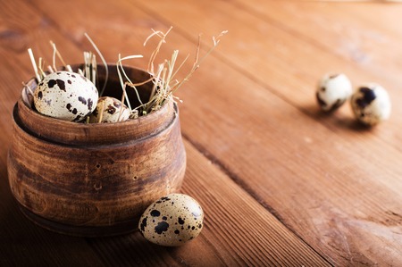 Quail eggs in a wooden bowl on a background.の写真素材