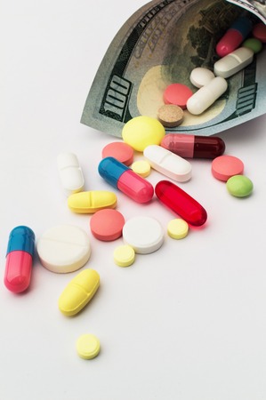Colored pills with money. Health costs a lot. medicineの写真素材