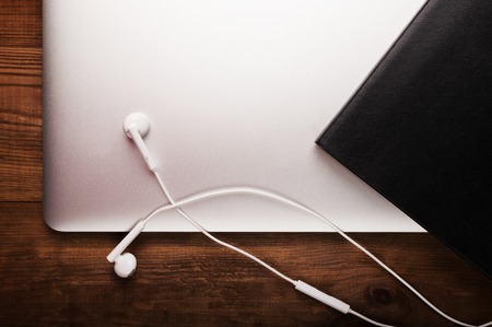 Notebook, headphone and diary on the wooden table. Business.の写真素材