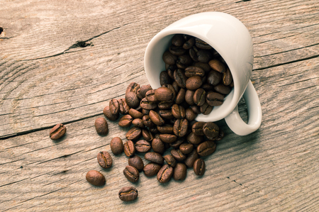 Coffee cup full of coffee beans on the wooden table. Horizonralの写真素材