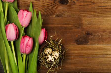 Chicken and quail eggs with tulips. Easter background.の写真素材
