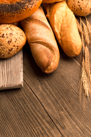 Bread, baguette, loaf and buns on the wooden deskの写真素材