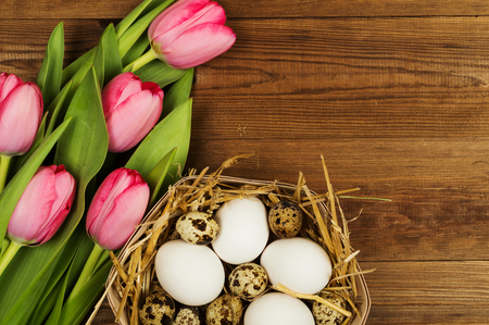 Chicken and quail eggs with tulips. Easter background.の写真素材