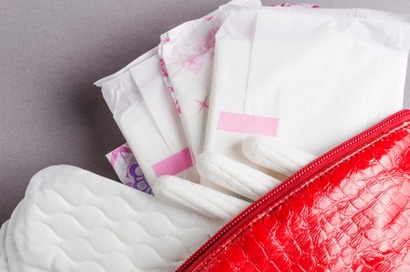Menstrual tampons and pads in cosmetic bag. Menstruation cycle. Hygiene and protection.の写真素材