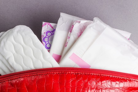 Menstrual tampons and pads in cosmetic bag. Menstruation cycle. Hygiene and protection.の写真素材