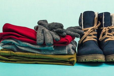 Woman clothes and boots on a blue background. Winter concept.の写真素材