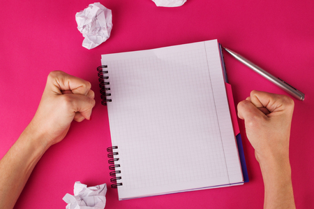 Concept of crisis in writing text. Womens hands, notebook, crumpled paper.の写真素材