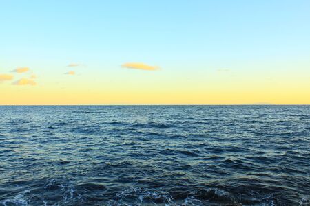 dark deep blue ocean and yellow horizon, sky changing colors at dusk. open water. horizontal, beautiful, and clean. Sagami Bay Japanの写真素材