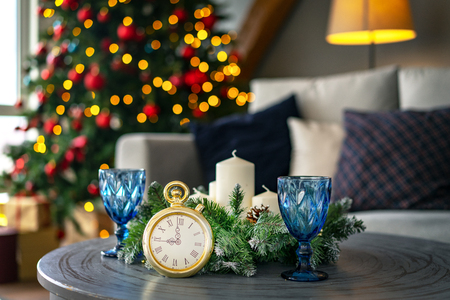 Countdown to midnight. Retro style clock counting last moments before Christmas or New Year  on the background to decorated fir tree.の写真素材