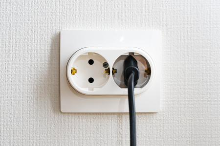 Close Up the electrical power socket and black plug socket on wall. The concept of energy savings.の写真素材