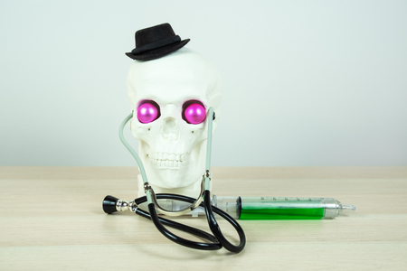skull sculpture  wearing black elegant hat, stratoscopes, with big medical syringe and bright pink eyes. parody of a medical worker. Copy space.の写真素材