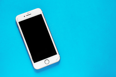 ROSTOV-ON-DON, RUSSIA - March 17, 2019: broken screen on smartphone Apple iPhone 8 on a blue background. Screen or safety glass replacement in your smartphone.の写真素材