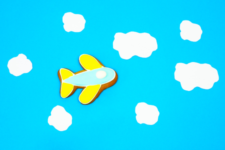 Gingerbread airplane  flying on a blue background, as the sky among the white clouds. tourism, air travel, logistic conceptの写真素材