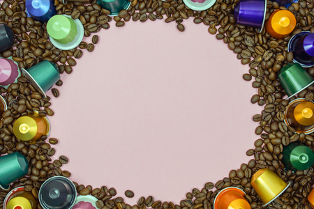 Multicolored coffee pod capsule on coffee beans close up. space for textのeditorial素材