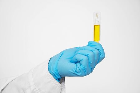 Pharmacist holds a yellow medicine capsule for a patient. Placebo drugs concept. Treatment and health care. medicine for various diseases hospital concept.の写真素材