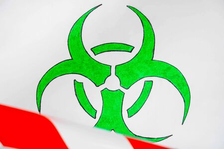  green and white biohazard sign of biological threat alert with signal tape on the wallの写真素材