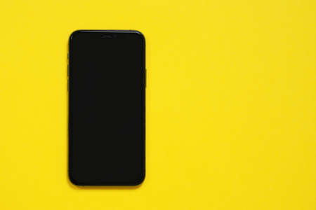 May 01, 2020, Rostov, Russia: Smartphone iPhone 11 Pro with blank black screen, model iPhone 10 or iPhone xs Max on a yellow background.のeditorial素材