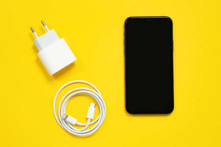 May 01, 2020, Rostov, Russia: Smartphone Apple iPhone screen up, wrapped in a ring USB Lightning...