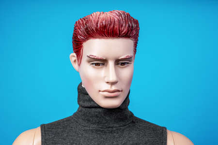 Close up portrait of mannequin man dressed in dark gray shirt without sleeves. Head with red hair...