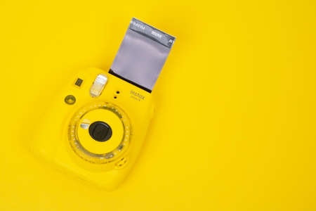 August 29, 2020, Rostov, Russia: Instant camera Fujifilm INSTAX MINI 9 with space for your printed photo on film card, yellow background, top view, copy space.のeditorial素材
