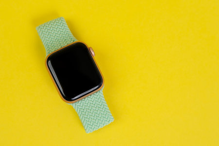 May 29, Rostov, Russia: Apple Watch Series 6 with green strap on yellow background, copy space. Smart device for an active lifestyle.のeditorial素材
