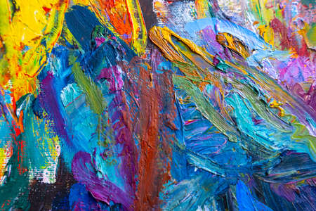 Multicolored small strokes of oil paint in blue, orange, purple shades on canvas, close up. Creative...