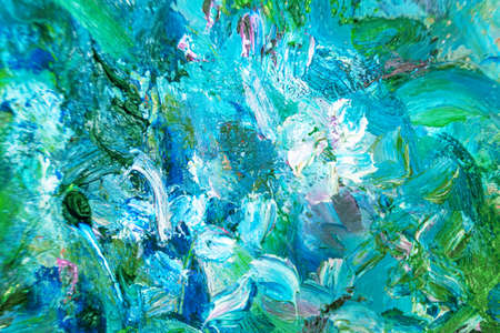 Multicolored large strokes of oil paint in blue, gteen shades on canvas, close up. Creative...