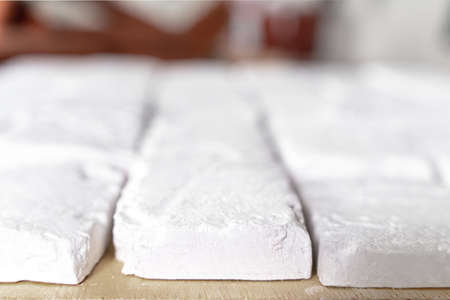 Gypsum tile based on casts of ancient bricks, covered with whitewash, side view, close up. Workflow...
