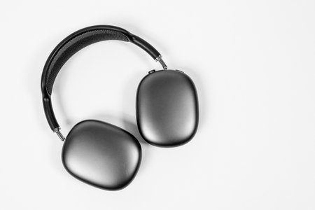Rostov, Russia - April 04, 2022: Stylish over-ear headphone Apple AirPods Max of space gray color with modern cushion and soft flexible canopy is lying on white background, top view, copy spaceのeditorial素材