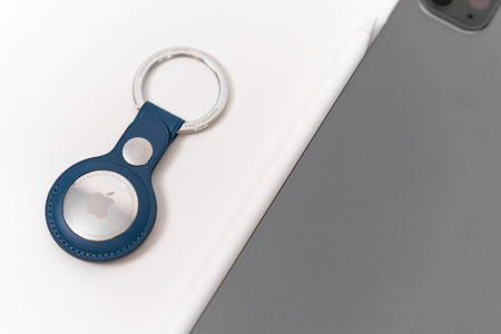Rostov, Russia - April 04, 2022: Apple Branded iPhone products: AirTags with case of Baltic blue color, iPad and Apple Pencil. Tools for illustrator, freelancer work.のeditorial素材