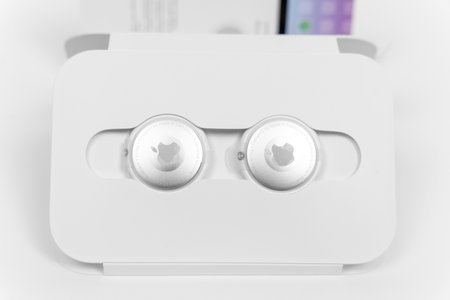 Rostov-on-Don, Russia - April 04, 2022: Brand new Apple AirTags unpacked in carton recyclable box and one another without box is lying on white tableのeditorial素材