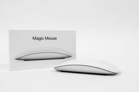 Rostov, Russia - April 04, 2022: Apple Magic Mouse. Wireless computer mouse Magic Mouse surface multi-touch streamline shape for sliding near to branded packaging, box on white backgroundのeditorial素材