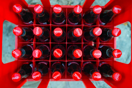Bar, Montenegro - November 13, 2022: Western sanctions Aesthetic photo crate of coca cola top view Red plastic box glass bottles red cap with coco cola logo Festive drink delivery New Year Eve partyのeditorial素材