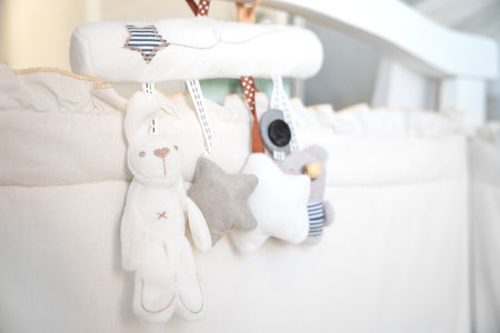 Close-up of soft fabric hanging toy for newborns hanging at head of the bed. Cozy interior of a children wooden crib handmade decoration, hanging rattles animals, sleep stars Gentle educational mobileの写真素材